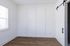 Bright and inviting room featuring elegant wood flooring, modern barn door, and abundant natural light.
