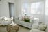Bright and inviting living room with chic modern furniture, featuring a plush gray sofa, colorful cushions, and abundant natural light.