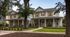 Charming duplex with welcoming front porches nestled in a serene neighborhood, surrounded by lush greenery and mature trees.