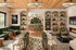 Luxurious living space featuring elegant green sofas, modern chandeliers, and a cozy fireplace, perfect for relaxation and entertainment.