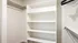 Walk-in closet at RailRunner townhomes featuring built-in shelving and hanging space.