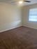 Inviting bedroom with cozy carpeting, bright natural light, and a modern ceiling fan.