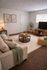 Cozy and inviting living room with a plush beige sofa, contemporary coffee table, and a sleek entertainment center, accented by warm lighting and tasteful decor.