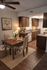 Charming kitchen and dining area with elegant wooden cabinets, cozy dining table set, and warm lighting, perfect for intimate dining experiences.