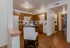 Kitchen featuring white appliances and plank flooring. A hallway is off to the right.
