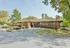 Charming building with a tile roof surrounded by lush greenery and vibrant flowers.