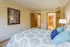Inviting bedroom with stylish decor, vibrant pillows, and warm wooden accents.