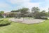 Charming playground with slides and swings surrounded by lush greenery in a residential area.