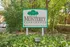 Monterey Apartments entrance sign surrounded by lush greenery.
