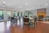 Elegant clubhouse interior with wooden flooring, modern round tables, and a cozy fireplace.