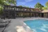 Modern apartment complex with pristine swimming pool and sun deck surrounded by lush greenery.
