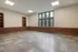 Spacious room with large windows and built-in wooden bookcases.