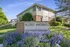 Front view of Hillcrest Apartments with manicured gardens and clear blue sky