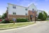 Exterior view of a charming three-story apartment building with brick and white siding.