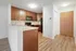 Contemporary kitchen with wooden cabinets, modern appliances, and inviting entrance.