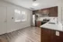 Sleek kitchen with stainless steel appliances, dark wood cabinets, and bright window lighting.