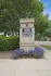 Brick entrance sign for Stationside Village surrounded by lush greenery and purple flowers.