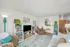 Inviting living room with plush sofa, decorative mirrors, and lush houseplant.