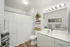 Inviting bathroom with a warm abiance, featuring a mirror and modern light fixture.
