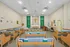 Peaceful chapel interior with altar, crucifix, religious statues, and green banners
