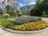 Beautifully landscaped entrance to an apartment complex with vibrant flowers and lush greenery