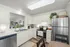 Cozy kitchen with modern white cabinetry, stainless steel appliances and comfortable seating
