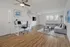 Modern living room with sleek design featuring a cozy gray sectional sofa, stylish floor lamp, and a contemporary workspace, complemented by wooden flooring and natural light.