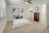 Elegant bedroom featuring cozy carpet, modern ceiling fan, and chic wall art, complete with a spacious walk-in closet.