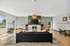 Chic apartment lounge featuring modern decor, elegant chandelier, fireplace, and ample natural light.