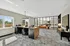 Bright, modern office space with sleek furnishings, featuring a large desk, comfortable seating, and floor-to-ceiling windows.