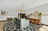 Chic apartment kitchen with geometric tile flooring, warm wooden cabinetry, and stylish pendant lighting creating a cozy dining area with modern flair.