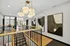 Elegant apartment hallway with modern abstract artwork, stylish lighting, and sleek railing design.