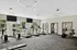 Bright, modern fitness center with treadmills and exercise bikes, highlighted by large windows and stylish pendant lighting.