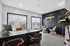Modern office space with sleek desk, comfortable seating, and large windows overlooking vibrant greenery.