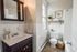 Bright, modern bathroom featuring a sleek vanity, large window, and elegant decor with green accents.