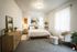 Inviting bedroom with a cozy queen bed, modern decor, and warm lighting, perfect for relaxation.