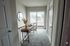 Bright hallway with plush carpet, stylish console table, and sliding glass doors leading to a sunny balcony.