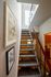 Inviting staircase with modern railing, enhanced by natural light and framed art, leading to upper living spaces.