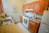 Charming kitchen with warm wooden cabinetry, modern appliances, and a cozy countertop arrangement.