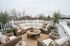 Charming rooftop terrace featuring cozy wicker seating, lush greenery, and a rustic wooden coffee table, ideal for outdoor relaxation.