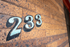 Charming brick exterior featuring bold '233' house number with artistic flair.