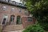 Charming historic townhouse with classic brick facade and lush greenery, offering an inviting and timeless appeal.