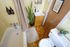 Charming bathroom with vintage tiles, lush potted plant, and a cozy bathtub for a relaxing retreat.