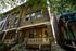 Charming brick townhouse with a classic facade, cozy porch, and lush green surroundings.