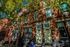 Charming sunlit brick townhouse with elegant windows and inviting entrances, surrounded by lush trees in a picturesque urban setting.