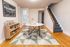 Charming dining area with a round marble table, sleek transparent chairs, and a geometric patterned rug, accentuated by a warm wooden floor and modern decor elements.