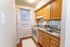 Cozy kitchen with modern appliances, wooden cabinets, and a bright window, ideal for culinary creativity.
