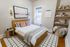 Cozy bedroom with modern decor, featuring a stylish wooden bed, soft lighting, and elegant shelving, perfect for relaxation.