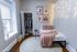 Charming bedroom with cozy ambiance featuring a neatly organized closet, soft lighting, and stylish wall art for modern living.