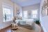 Bright and cozy bedroom with modern decor, large windows, and a stylish bohemian touch, perfect for relaxation.